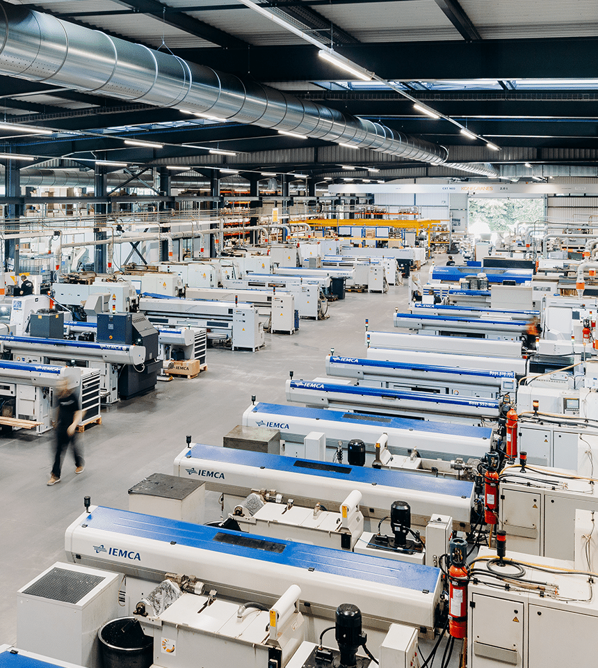 Man Using Measuring Tape in Factory Setting Man Using Measuring Tape in Factory Setting